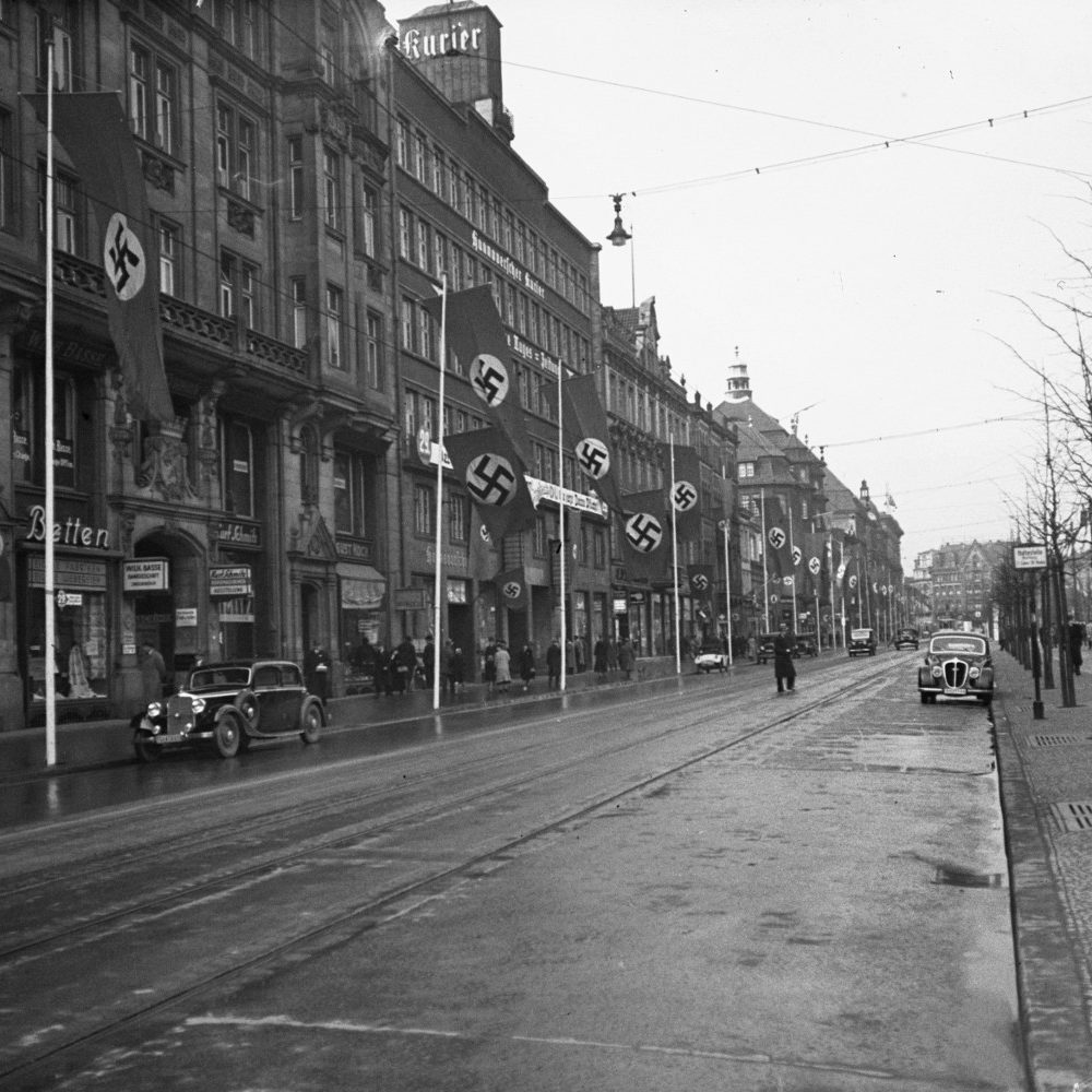 Hannover: Bankhaus Basse in der Georgstraße (links hinter dem PKW), der Salon von Käte Steinitz befand sich in der Beletage im ersten Obergeschoss. Dahinter gelegen das 1927 für den „Hannoverschen Kurier“ erbaute Pressehaus. Im Juli 1934 zog hier die nationalsozialistische „Niedersächsische Tageszeitung“ NTZ ein. Foto von Wilhelm Hauschild, 1937. Hauschild Archiv im Historischen Museum Hannover