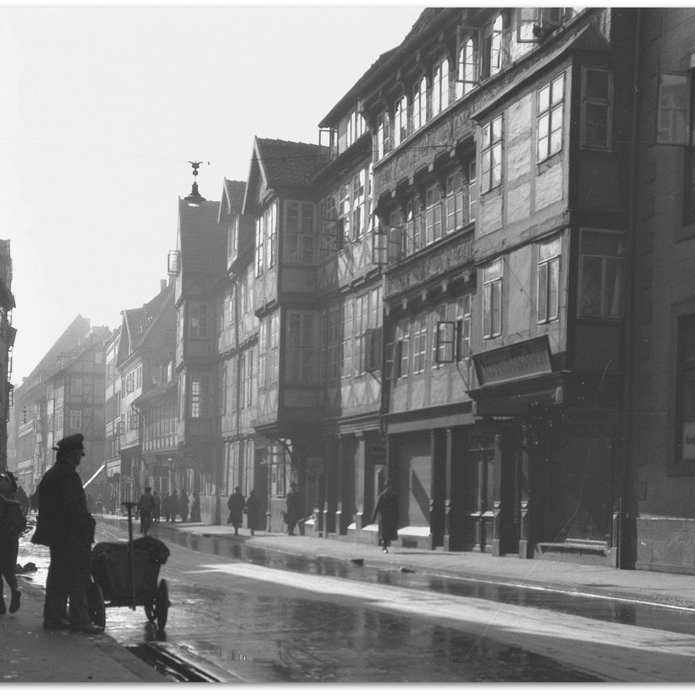 Hannover: Burgstraße in Richtung Holzmarkt, links die Einmündung der Gasse Tiefental (heute: Johann-Trollmann-Weg). Das erste Fachwerkhaus der rechten Straßenseite überstand den Bombenkrieg und ist heute das älteste Gebäude der Stadt. Dahinter mit zwei Erkern das "Burghaus" (später: "Rusthaus") des Verein für Fortbildung. Bildarchiv Historisches Museum Hannover