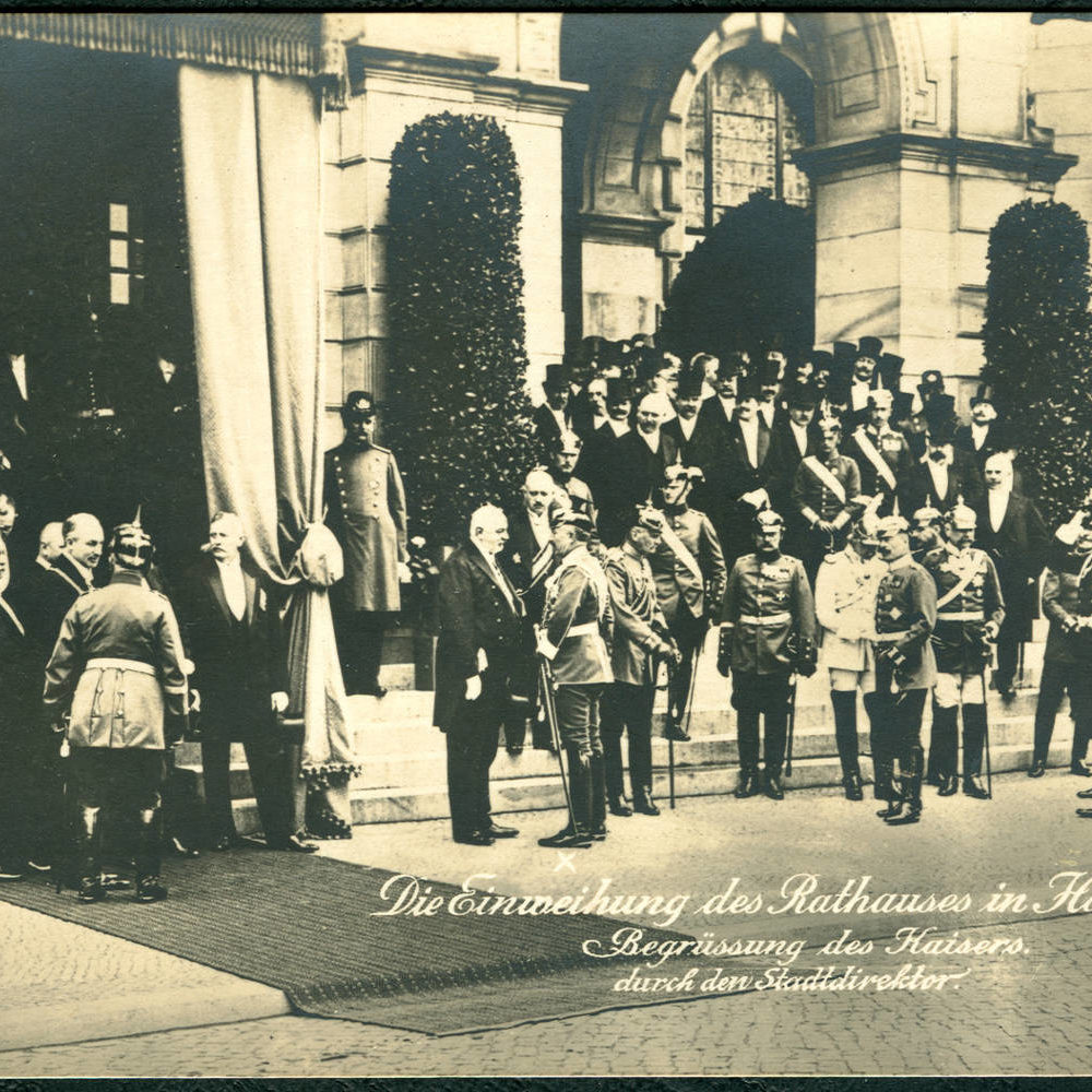 Hannover: Bei der Einweihung des Neuen Rathauses am 20. Juni 1913 war auch Kaiser Wilhelm II. zugegen. Während der bürgerliche Stadtdirektor Heinrich Tramm auf den Treppen des Rathauses auf die Begrüßung seiner Majestät zu warten hatte, widmete sich WII dem Adel und insbesondere den vor dem Rathaus versammelten Militärs. Zeitgenössische Ansichtskarte. Wikimedia Commons. Scan vom Original: Bernd Schwabe in Hannover