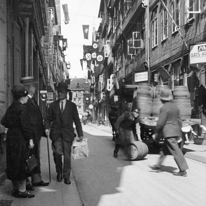 Hannover: Die Dammstraße (heute: Bohlendamm) in Richtung Marktplatz im Reichstagswahlkampf vom Juli 1932. Selbst in diesem Arbeiterquartier dominieren Hakenkreuze über die drei Pfeile der sozialdemokratischen „Eisernen Front“. Die Wahl endete mit einem Erdrutschsieg der Nazis. Bildarchiv Historisches Museum Hannover