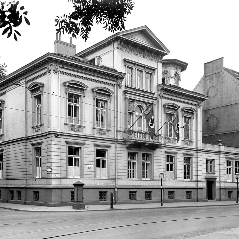 Hannover: Eckgebäude Straße der SA 26 (vor 1933: Lange Laube) und Dincklagestraße (vor 1933: Kurze Straße). Links am Bildrand das Gebäude der Gauleitung in der Dincklagestraße 3. Lt. Adressbuch 1939 gehörte das Eckhaus der NSDAP-Gauleitung, Verwalter war der Gauschatzmeister, Bewohner der NS-Rechtswahrerbund. 1941 ist in Hausnummer 25 rechts am Bildrand das nationalsozialistische Langemarck-Studium untergekommen, die Hausnummern 24 und 23 haben als Besitzer ebenfalls die Gauleitung und als Bewohner u.a. die NS-Frauenschaft und das Deutsche Frauenwerk. Foto von 1937. HAZ-Hauschild-Archiv im Historischen Museum Hannover